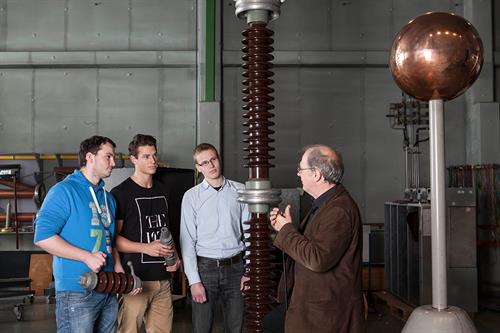 Dieses Bild zeigt drei männliche Studierende in einem Labor für elektrische Maschinen.